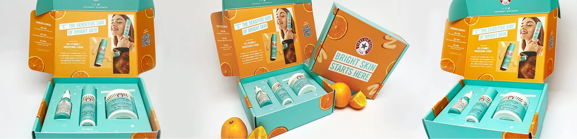 An open skincare product box with orange-themed graphics, featuring a tube, bottle, and jar labeled for brightening skin, alongside promotional text and images inside the lid.
